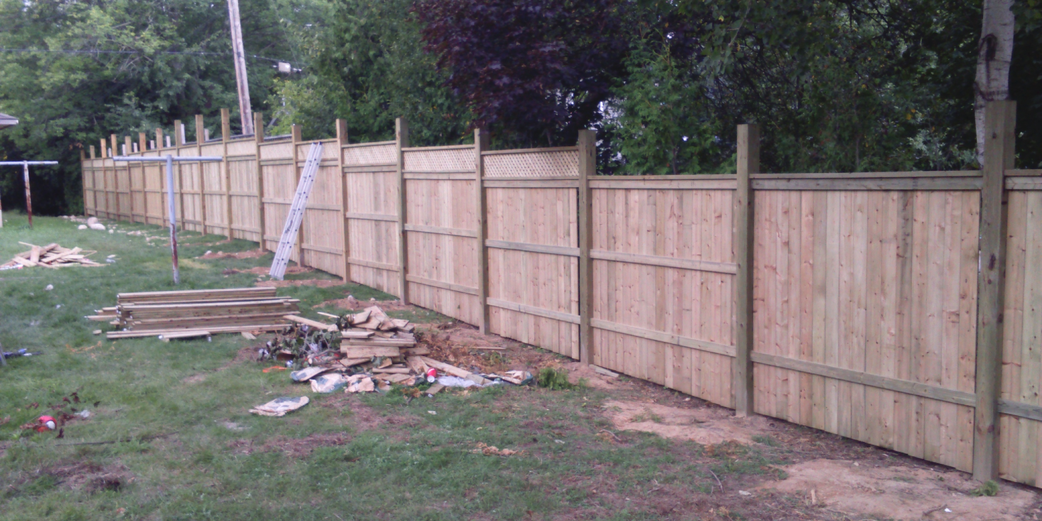 Wooden fence under construction in a yard.