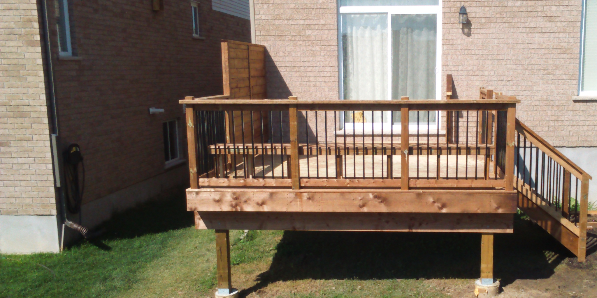 Wooden deck attached to brick house.